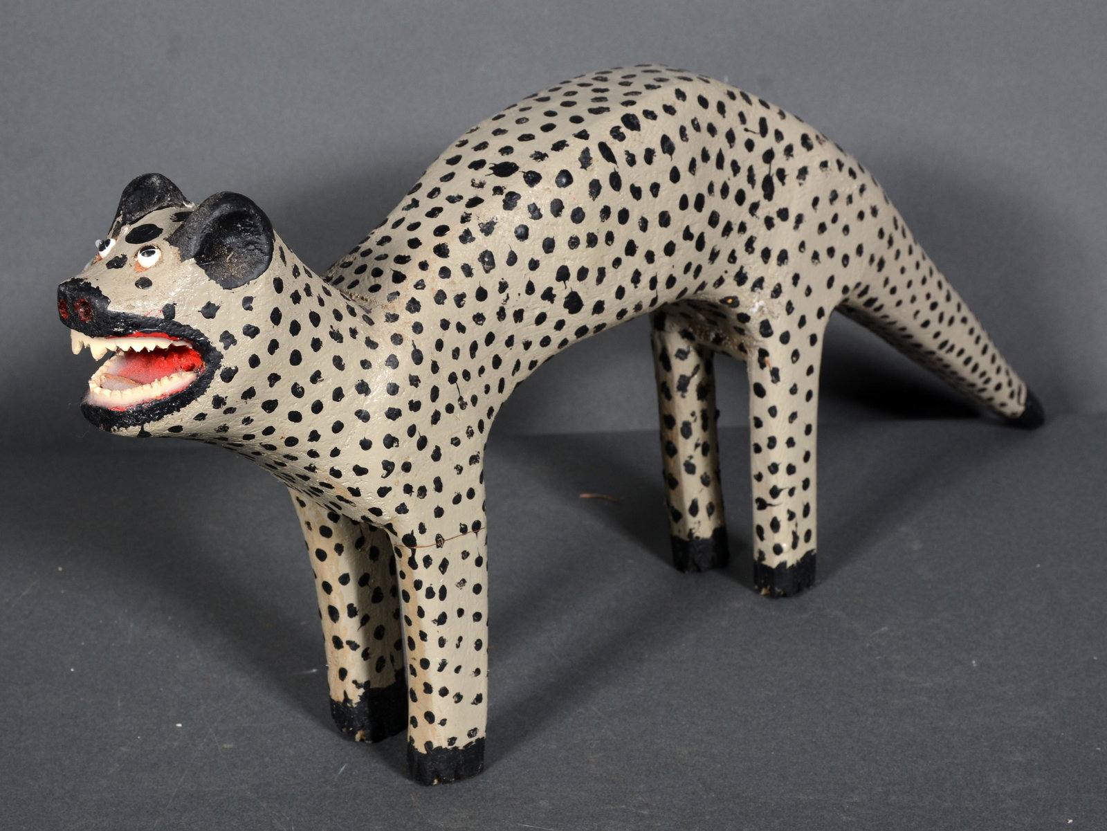 Denzil Goodpaster. Spotted Pole Cat.: Denzil Goodpaster. Spotted Pole Cat. Initialed. Not dated. Carved and painted wood, plastic teeth. Possible repair to 2 front legs otherwise great condition. 8” x 21”. Est. $200-400. Ship: