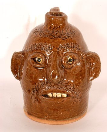 Reggie Meaders. Face Jug.: Face Jug.Ceramic with mustard-colored glaze. Signed on back. 8"h. Mint condition. Est. $200-300. Ship: $35