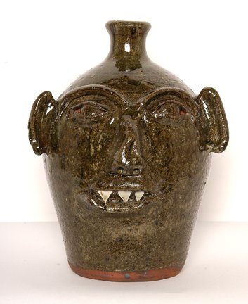 B.B. Craig. Vampire Face Jug.: Vampire Face Jug.Alkaline glaze, fired in wood-burning kiln. Single eyebrow, long ears, pointy china plate teeth. Stamped, "B.B. Craig, Vale, NC." 12"h. Mint condition. Est. $1,000-1,500. Ship: $40