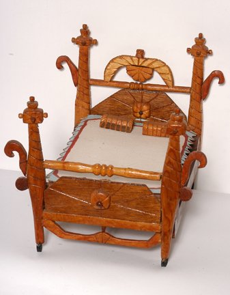 Willie Massey. Four Poster Doll Bed.: Four Poster Doll Bed.Intricately carved wood, cardboard, paint. 11"h x 13"x 8". Excellent condition. Est. $200-300. Ship: $45