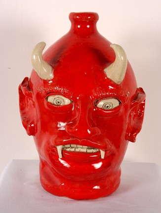 Eric Hewell Red Devil Face Jug.: Red glaze. Signed and numbered, #9. 10.75"h. Mint condition. Est. $100-200. Ship: $45