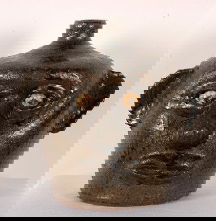 Lanier Meaders Bulbous-Nose Face Jug.: Tobacco-spit glaze. No teeth. Slight kiln separation near handle, otherwise mint condition. Signed. 8" h. Est. $2,000-3,000. Ship: $50