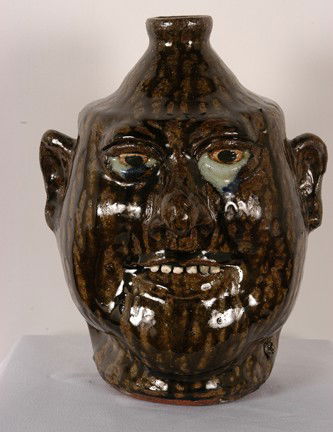 Lanier Meaders Runny-Eyed Face Jug.: Very tall with beautiful tobacco-spit glaze and nice drips. Clay teeth. c. 1985. 11"h. Mint condition. Est. $1,000-2,000. Ship: $50