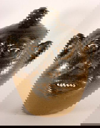 Lanier Meaders Bulbous-Nose Face Jug.: Two-tone glaze. Top is tobacco-spit glaze, bottom half is matte-finish. c. mid 1980's. 9"h. Est. $1,000-2,000. Ship: $45