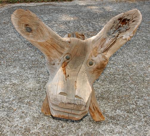 Jesse Aaron Two-Headed Horse.: Carved tree stump with tin eyes. Initialed. Some condition problems, wood is weathered. Photo of Jesse sitting on stump included with lot. 54" x 35" x 37". Est. $1,000-2,000. Buyer is responsible for 