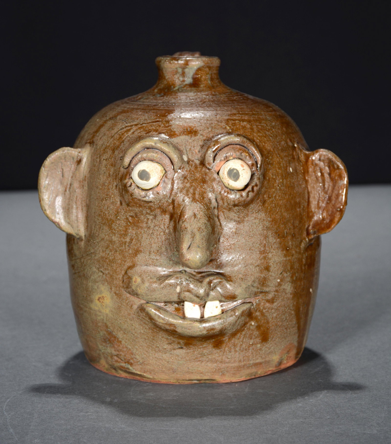 Reggie Meaders. Celebration Face Jug With Buck Teeth.: Reggie Meaders. 100-Year Meaders Family Celebration Face Jug With Buck Teeth. Signed in script with dates 1892-1992. Mint condition. 7"h. Est. $200-300. Ship: $45