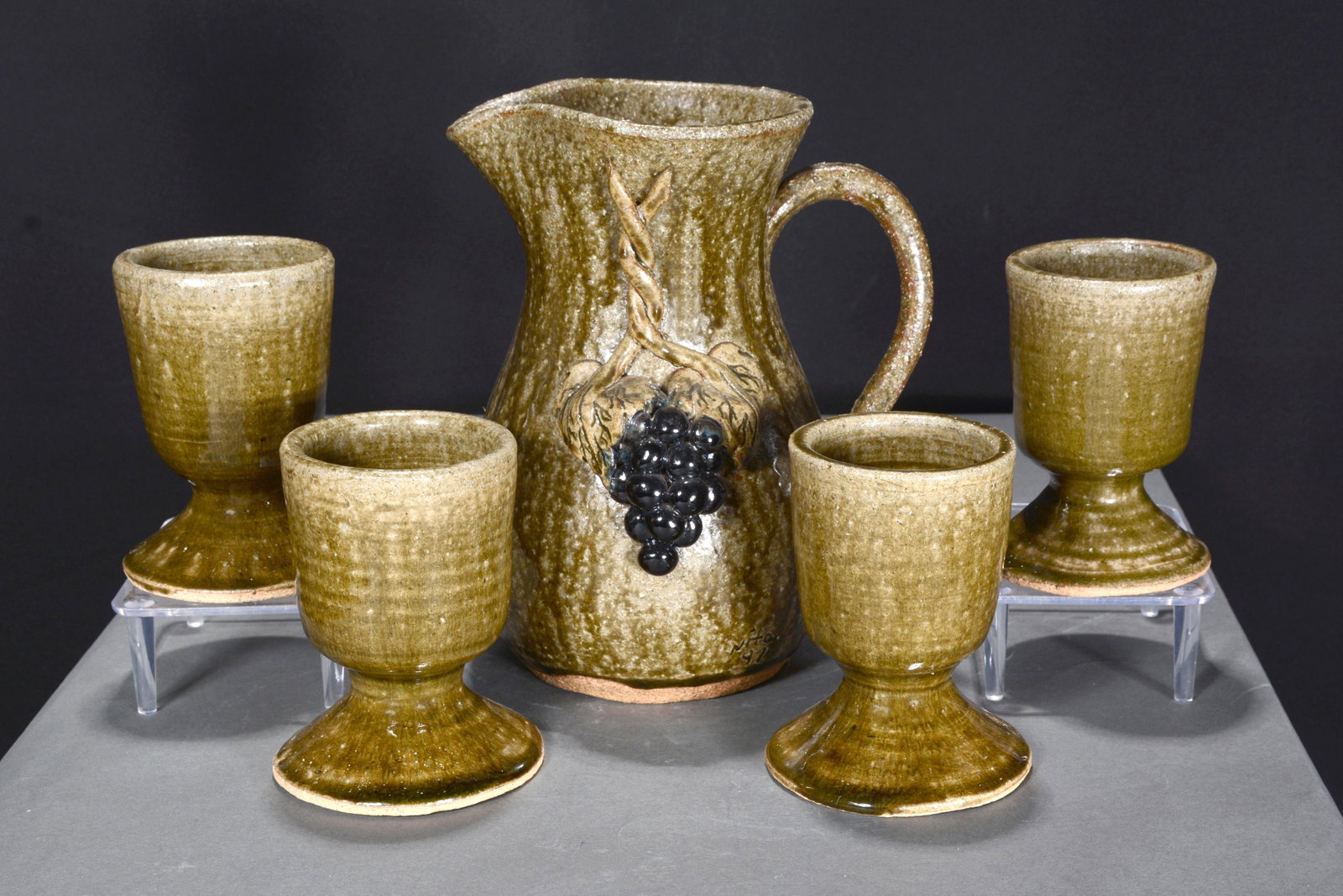 Anita Meaders. Grape Pitcher With 4 Wine Goblets.: Anita Meaders. Grape Decorated Pitcher With Four Wine Goblets. 1997. All are signed. Pitcher is dated and is 8.5"h. Wine goblets are 5"h. Mint condition. Est. $200-400. Ship: $55