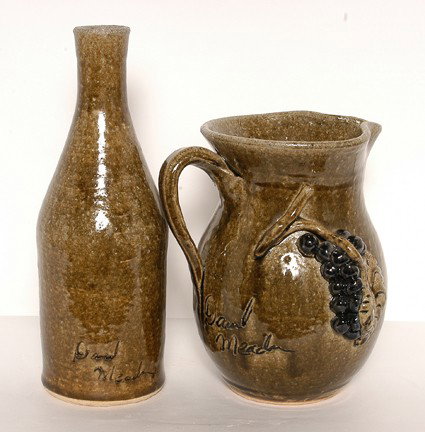 David Meaders Moonshine Bottle & Grape Pitcher.: Moonshine Bottle and Grape Pitcher.Bottle is 11h, ash glaze, signed in script with, "Moonshine XXX." Pitcher is 8"h. Signed in script. Mint condition. Est. $200-300. Ship: $55"