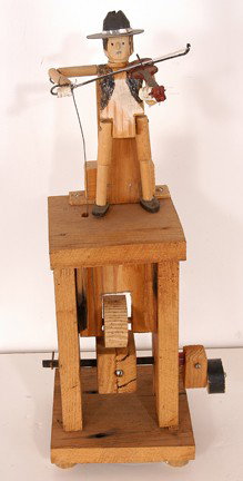 H.J. Wallace Fiddle Player Mechanical Crank Toy.: Paint and marker on wood. 17.5"h x 5.5" x 5.5". Excellent condition. Est. $200-300. Ship: $45. Consignor purchased this piece from North Georgia carver, H.J. Wallace approximately 30 years ago.