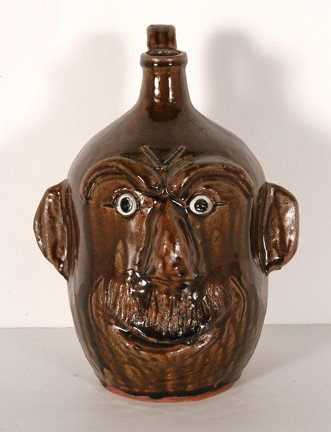 Jeff Meaders. Face Jug With Etched Moustache.: Brown tobacco-spit glaze. Signed and dated, 2003. 10"h. Est. $100-200. Ship: $40