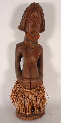 Tchokwe Tribe Sango Female Figure.: Carved wood, grass, cloth, nails. Fair condition. Natural wood splits. 25" x 6" x 6". Est. $100-200. Ship: $65. This is a sublime mid 20th century carving of a Sango Figure. Neighbors (actually a sub 