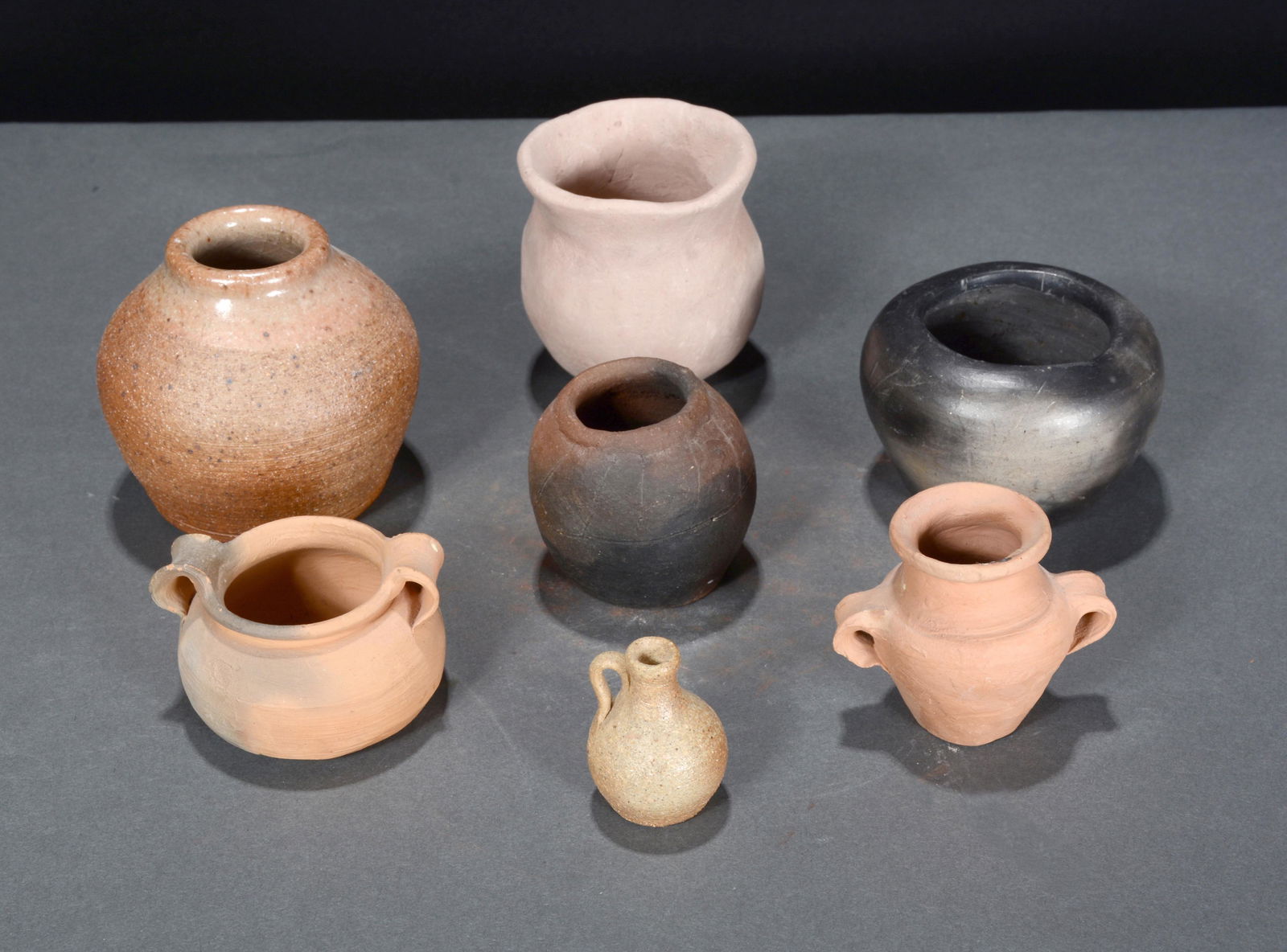 7 Miniature Primitive Pots. (1 of 2)