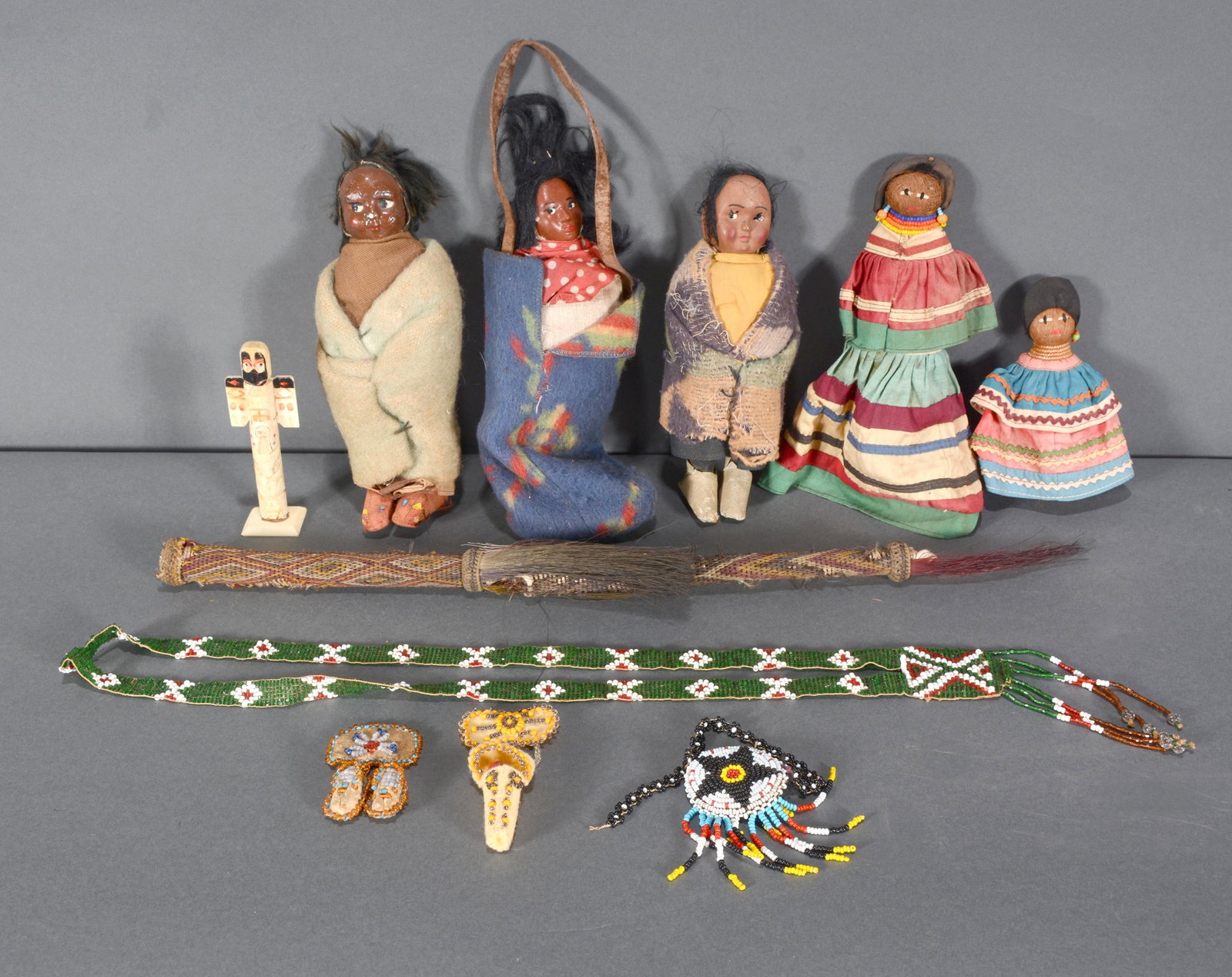 Native American Dolls and Jewelry.: Variety of NA Tribes. Dolls and Jewelry. Works include Skookum-style dolls, Seminole Dolls, miniature bone totem, beaded jewelry. Good to fair condition. Tallest is 8" h. Est. $100-200. Ship: $45
