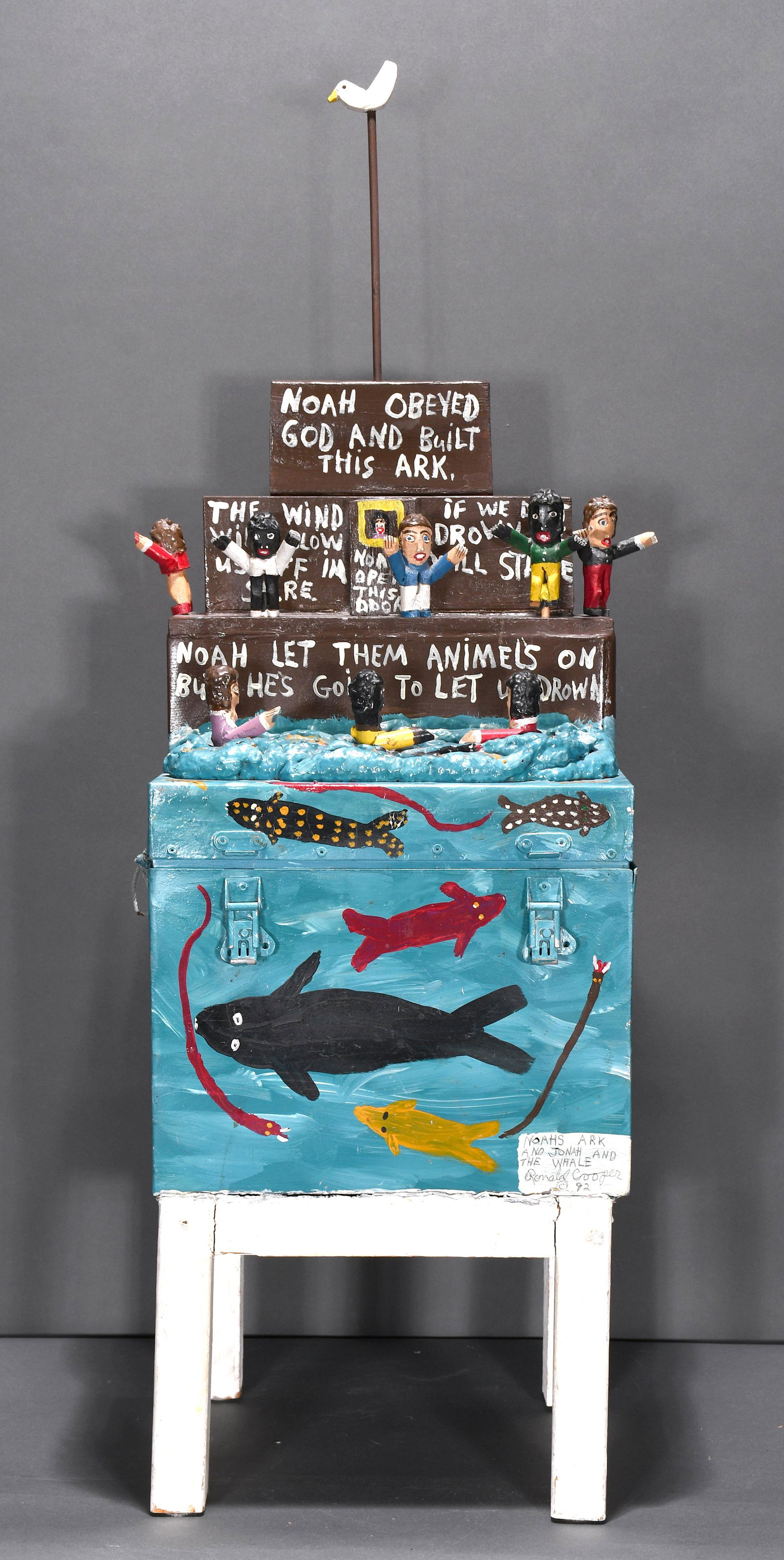 Ronald Cooper. Noah's Ark & Jonah & The Whale.: Ronald Cooper. Noah's Ark & Jonah And The Whale. 1992. Signed, dated, titled. Carved and painted wood on mixed media. Excellent condition. 31.5" x 10" x 13". Est. $400-600. Buyer is responsible for sh