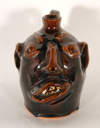 Brown Pottery. Face Jug.: Brown Pottery. Face Jug. Traditional Brown Family glaze. Stamped on bottom with handmade Arden, NC. Mint condition. 7” h. Provenance: The George and Sue Viener. Est. $100-200. Ship: $35