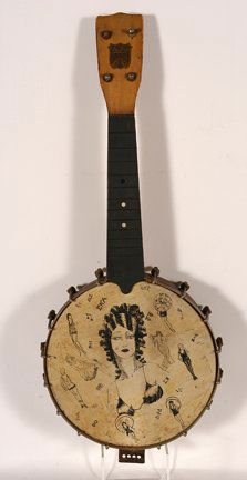 True Fret Banjo. Flapper Girl.: True Fret Banjo. Flapper Girl. Wood, metal, skin and ink. Very good condition. 21”h x 8”diameter. Est. $300-500. Ship: $35
