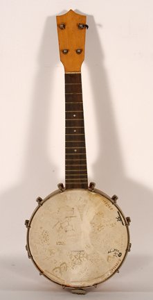 Columbia Ukulele. Cartoon Faces & Signatures.: Columbia Ukulele. Cartoon Faces and Signatures. 1926. Wood, metal and skin. Signed and dated. Skin separating from base, otherwise good condition. 21”h x 7.5”. Est. $200-300. Ship: $35