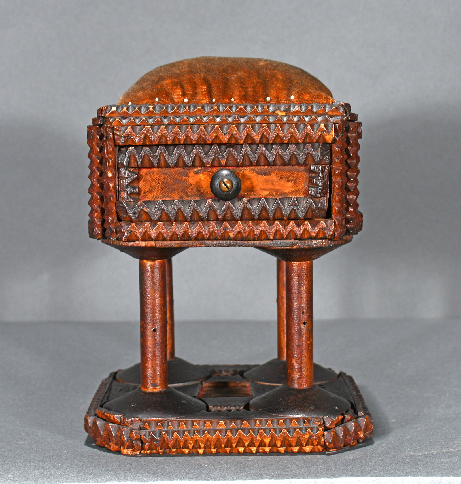 Tramp Art Pin Cushion.: Anonymous Tramp Art Pin Cushion. Chip carved and stained wood with old spools and velvet pin cushion. Minor loss of fabric on back otherwise excellent condition. 7"w x 8.5"h x 6.5"d. Provenance: The R