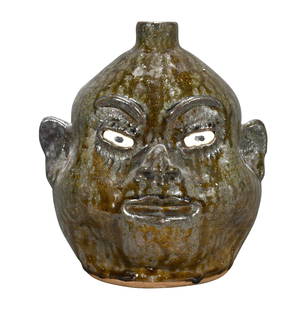 Lanier Meaders. Puffy Cheeks Toothless Face Jug.: Lanier Meaders. Puffy Cheeks Toothless Face Jug. c. late 1970's. Signed with original price tag on base. Beautiful tobacco-spit glaze. Mint condition. 10" h. Est. $1,000-1,500. Ship: $55