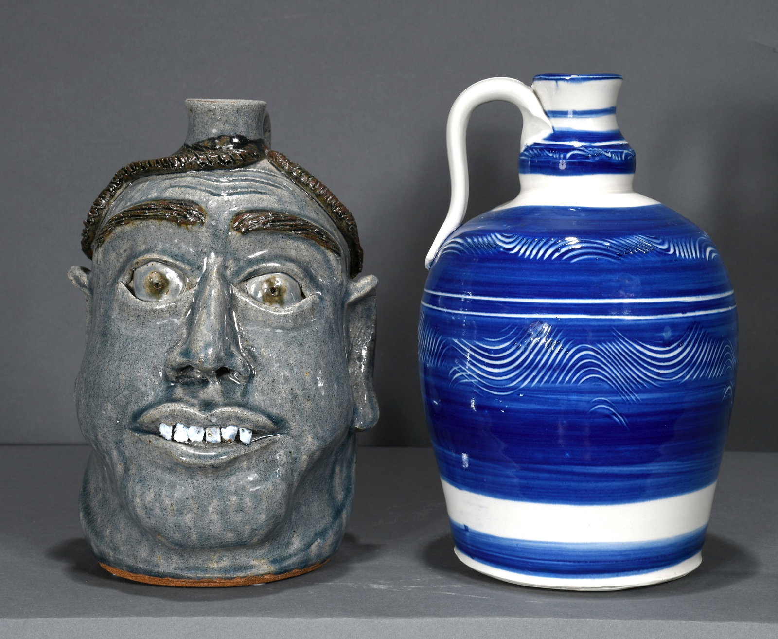 Michael Crocker. Blue Face Jug with Rock Teeth & Blue & White Jug.: Michael Crocker. Blue Face Jug with Rock Teeth & Blue & White Jug. 2001 and 2012. Signed and dated. Mint condition. Tallest is 10" h. Est. $200-300. Ship: $65