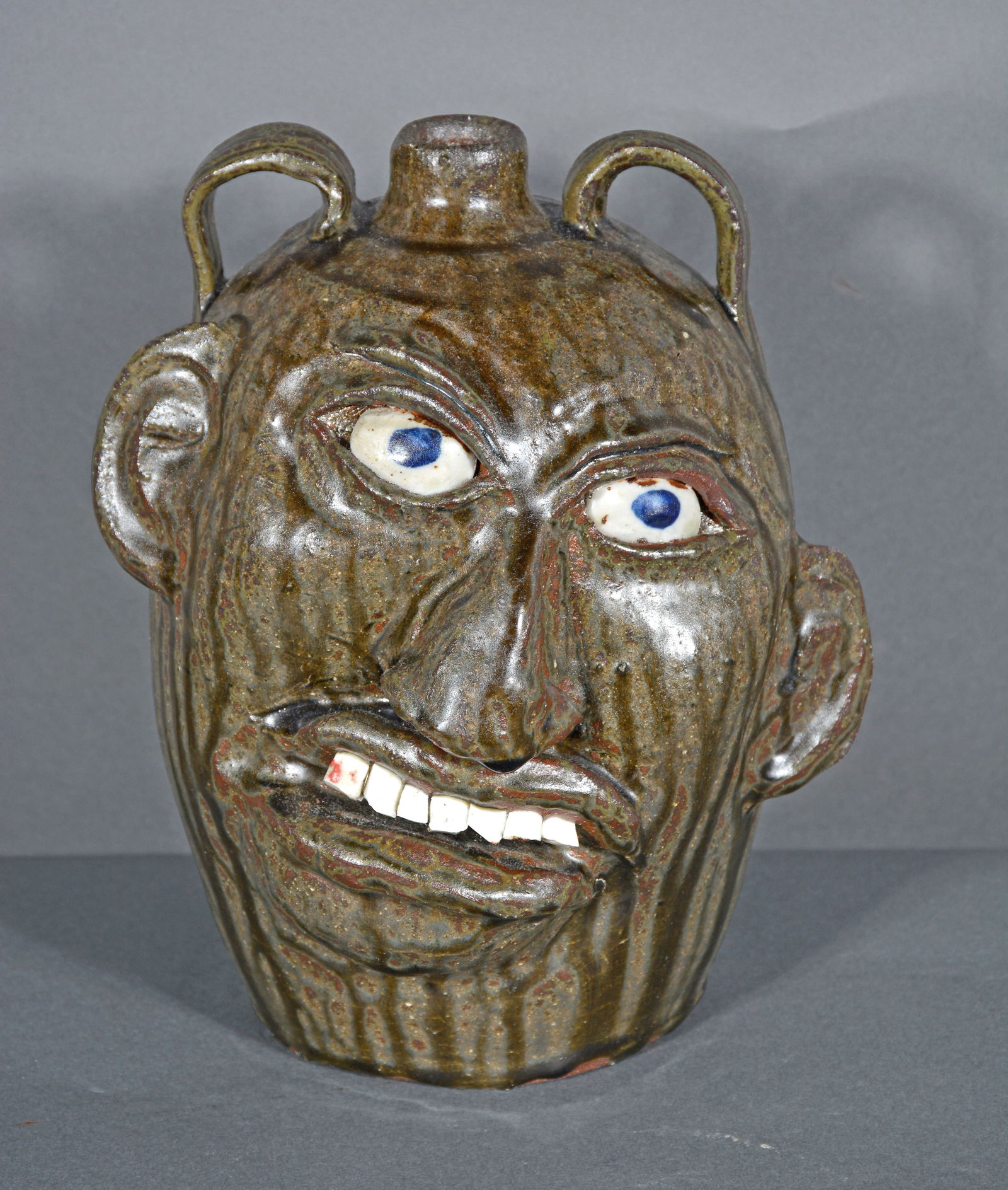 Chester Hewell. Crooked Smile Face Jug. Auction
