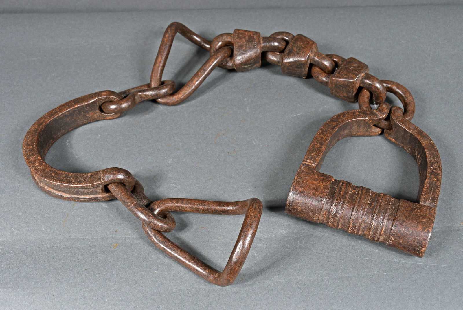 Wrought Iron Ankle Slave Shackles.: Wrought Iron Ankle Slave Shackles. c. Civil War Era. Oversized slave shackle with very heavy joints and collar. Nicely aged with patina, excellent condition. 29.5" long. Provenance: The Richard Harris