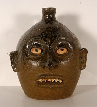 Lanier Meaders. Canon Ball Rock Tooth Face Jug.: Lanier Meaders. Canon Ball Rock Tooth Face Jug. c. 1960’s-70’s. Signed. Quartz teeth with floating early eyes. Ash glaze with some matt coloration. Mint condtion. 10”h. Est. $2,000-3,000. Ship: