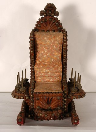 Over The Top Sewing & Pincushion Chair Box: Anonymous Over The Top Sewing & Pincushion Chair Box. Not signed. c. 1900’s. Carved wood with brass tacks and metal spool poles, cloth and cushion seat with drawer. Excellent condition. Strange and 