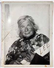 Lee Godie. Self-Portrait Photo Holding Artwork.: Lee Godie. (1908-1994, Illinois). Self-Portrait Photograph Holding Rolled Artwork. Signed. Original black and white photograph. Minor scratches and slight toning, otherwise great condition. Image is 4