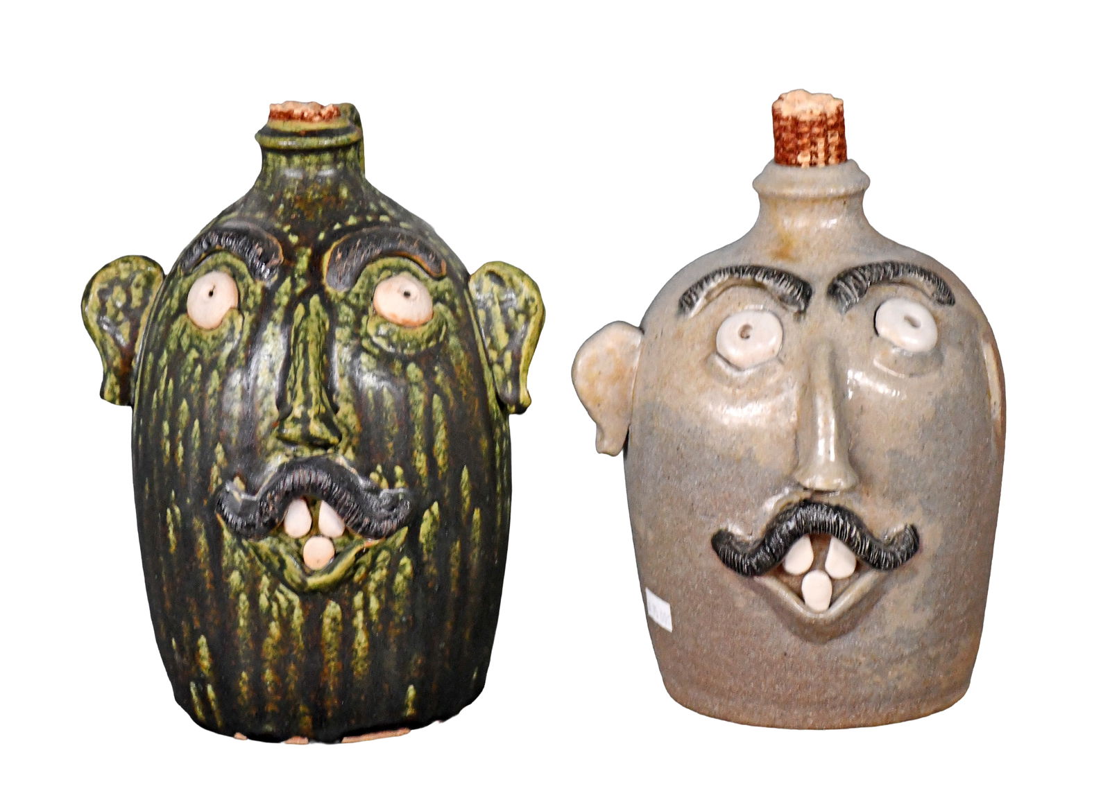 Sid Luck. Pair of Face Jugs.: Sid Luck. Pair of Face Jugs. 2010 & 2012. Signed and dated. Salt glazed jug is missing an ear, green ash glazed jug is in mint condition. Average is 9" h. Est. $100-200. Ship: $85 Please Read