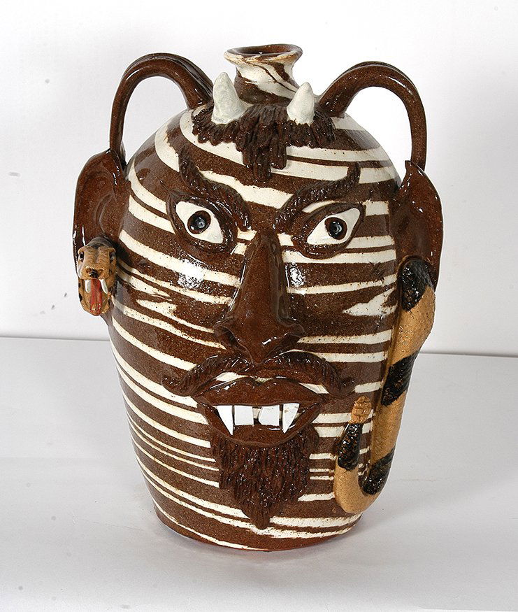 Albert Hodge. Devil Face Jug w Snake.: Albert Hodge. Swirl Devil Face Jug With Snake. c. 2007. Signed and stamped. 13”h. Devil with white horns and four porcelain teeth and fangs, snake entering and exiting ears; scars on cheek and mole;