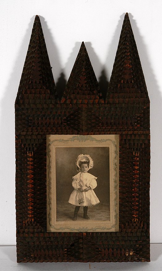 Tramp Art Steeple Frame w Photo.: Tramp Art Steeple Frame With Photo Of Young Girl. Chip-carved wood. Excellent condition. 13” x 7” x 1.5”. Est. $200-400. Ship: $35
