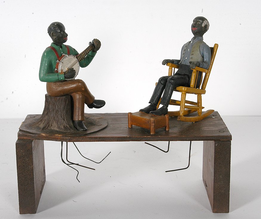 Banjo Player & Man In Rocker.: Anonymous Animated Articulated Black Banjo Player & Man In Rocker. c. 1930’s. Wire mechanics with carved wood. Jointed figures, working condition. Excellent condition. 9” x 10” x 4.5”. Est. $8
