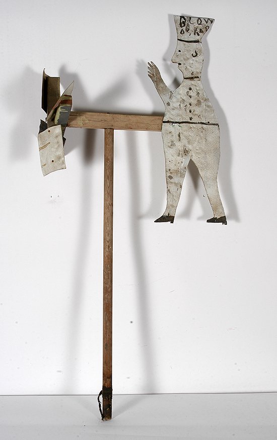 R.A. Miller. White Blow Oskar Whirligig.: R.A. Miller. Early White Blow Oskar Whirligig. Cut and painted tin attached to wood. Excellent condition. 54”h with stake. Image is 28” x 24”. Est. $300-500. Buyer is responsible for shipping.