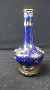 Chinese Qing Dynasty Cloisonne Dragon Vase: A Qing dynasty style Chinese cloisonne dragon vase; An exquisitely detailed dragon wraps itself around the body of the vase; A subtle gold cloud pattern floats over a royal blue background; 