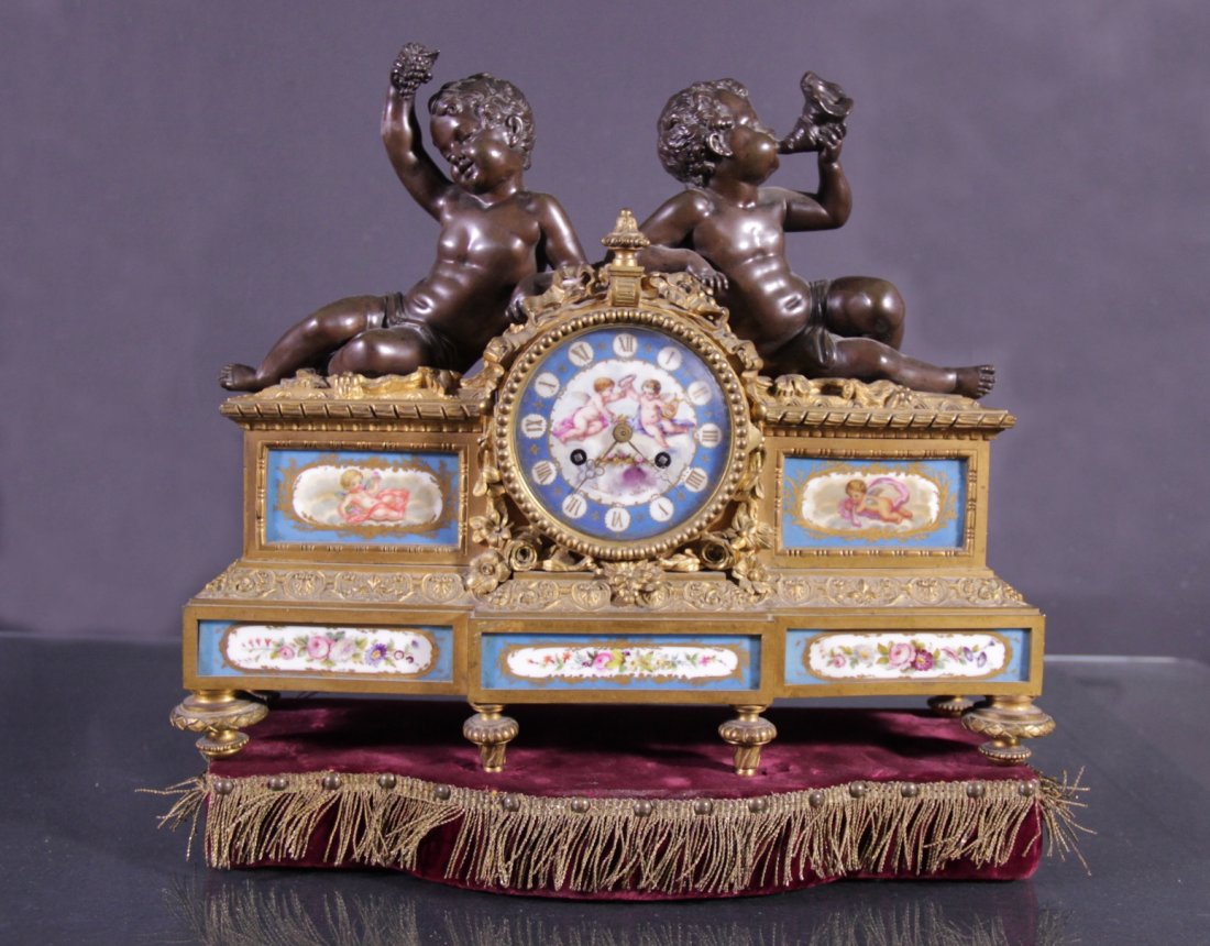 Gilt bronze and burnished clock - Orologio in bronzo: Gilt bronze and burnished clock with Sevres porcelain plaques.France Napoleon III. H 12,6 in l 15,35 in p 5,12 in. Orologio in bronzo dorato e brunito con placche in porcellana Sevres.Francia Napoleon