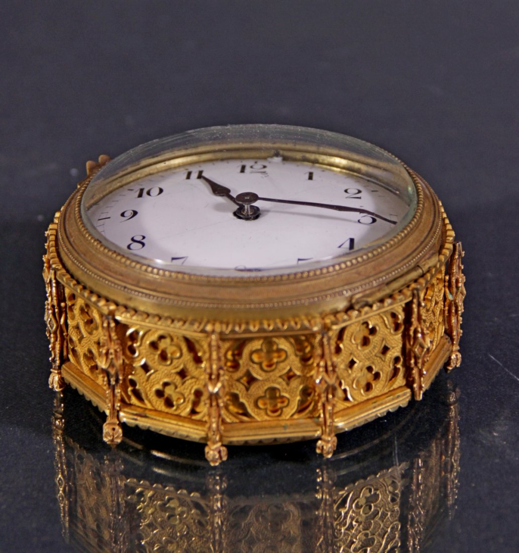 An ormolu clock- Oroglio in bronzo dorato: An ormolu neogothic clock. France, II mid-nineteenth Century.H 36 in d 4,53 in. Orologio in bronzo dorato neogotico. Francia, II metà XIX Sec. H 6 d 11,5 cm.