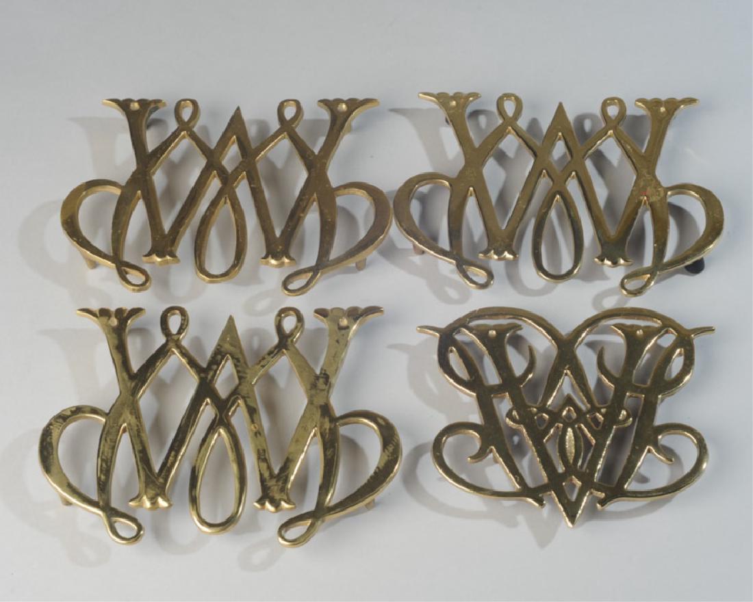 Four Virginia Metalcrafters Brass Trivets: Williamsburg 10-8 copyright 1950, three CW 10-11 William & Mary Williamsburg copyright 1950. Largest: approx. 6" x 7 3/4".