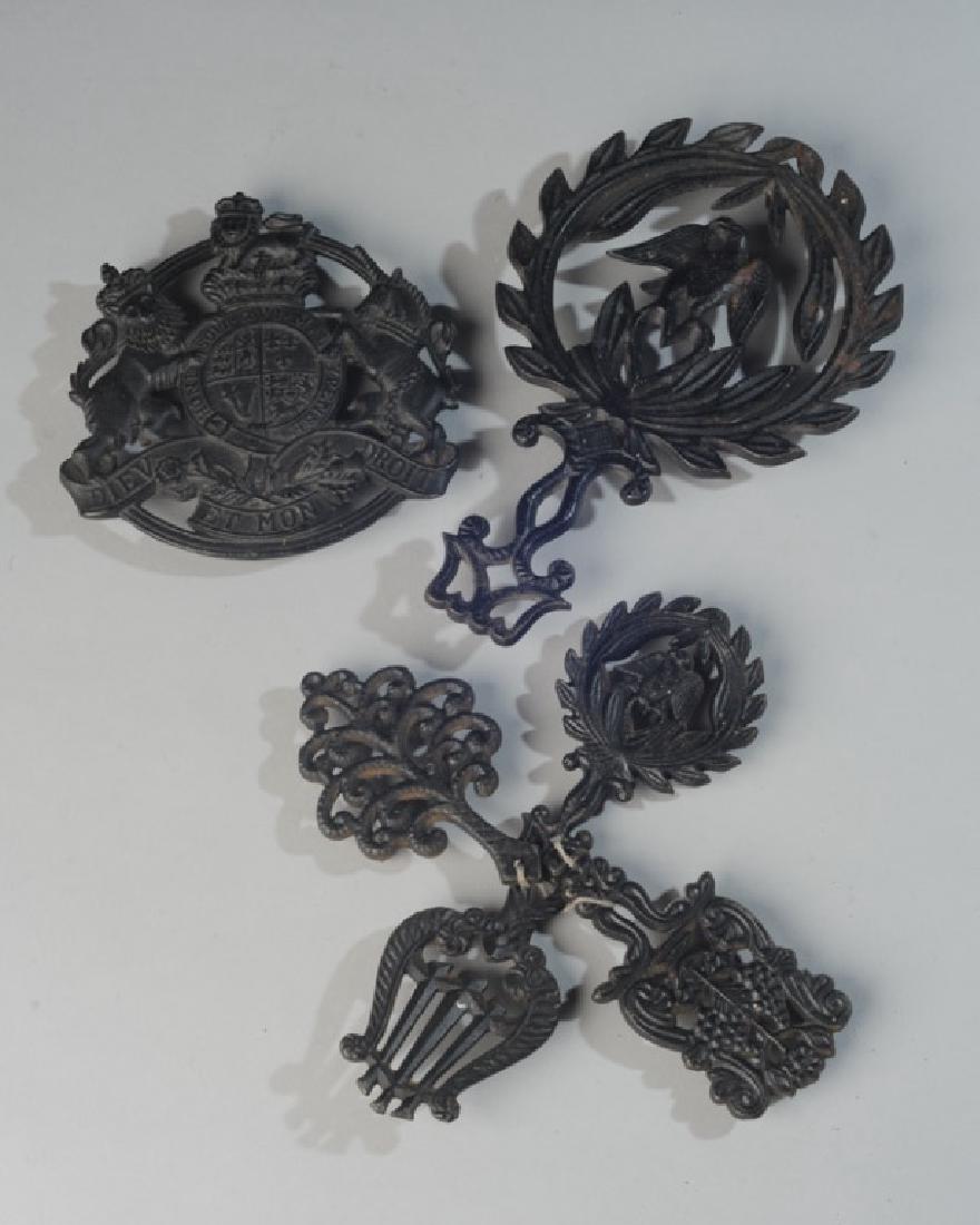 Six Virginia Metalcrafters Iron Trivets: One is CW 10-17 Kings Arms copyright 1953, one is an eagle 9-3, four small trivets. Largest: approx. 9" x 6".