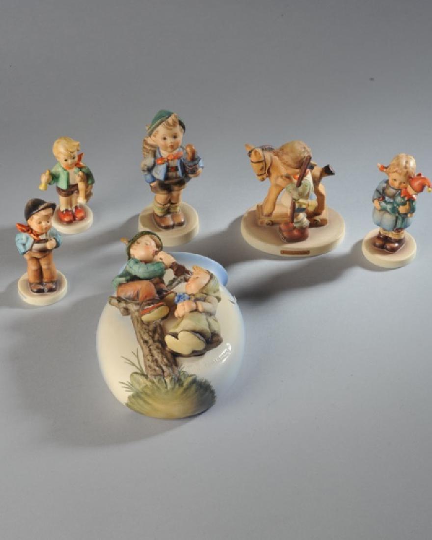 Six Hummel Figures: A wall pocket with boy and girl on a tree, "Lucky Fellow", child with toys, "Christmas Surprise", boy with a pig in a basket (small chip), "Prayer before Battle".