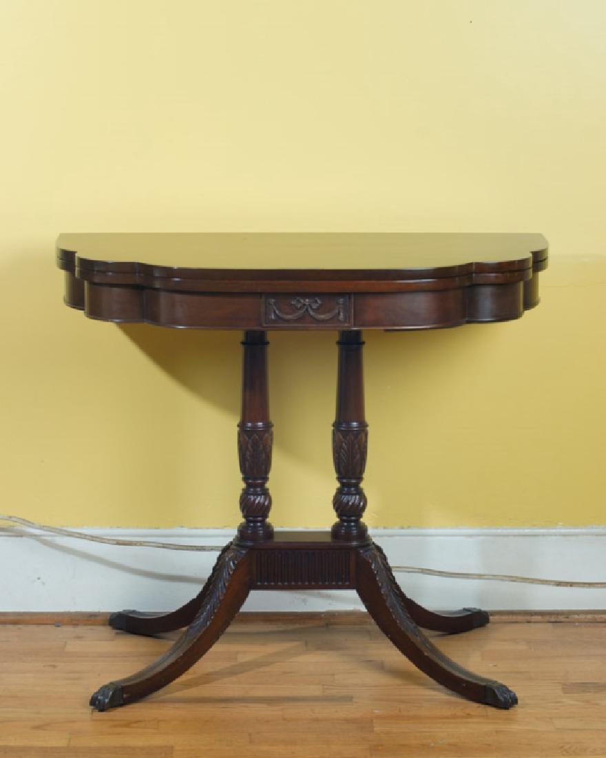Duncan Phyfe Style Game Table: Probably mahogany, folding top, garland motif, two turned and carved center supports with four curvilinear, carved legs terminating in brass claw feet. Provenance: Estate of Mary Helen Jessup of Charl