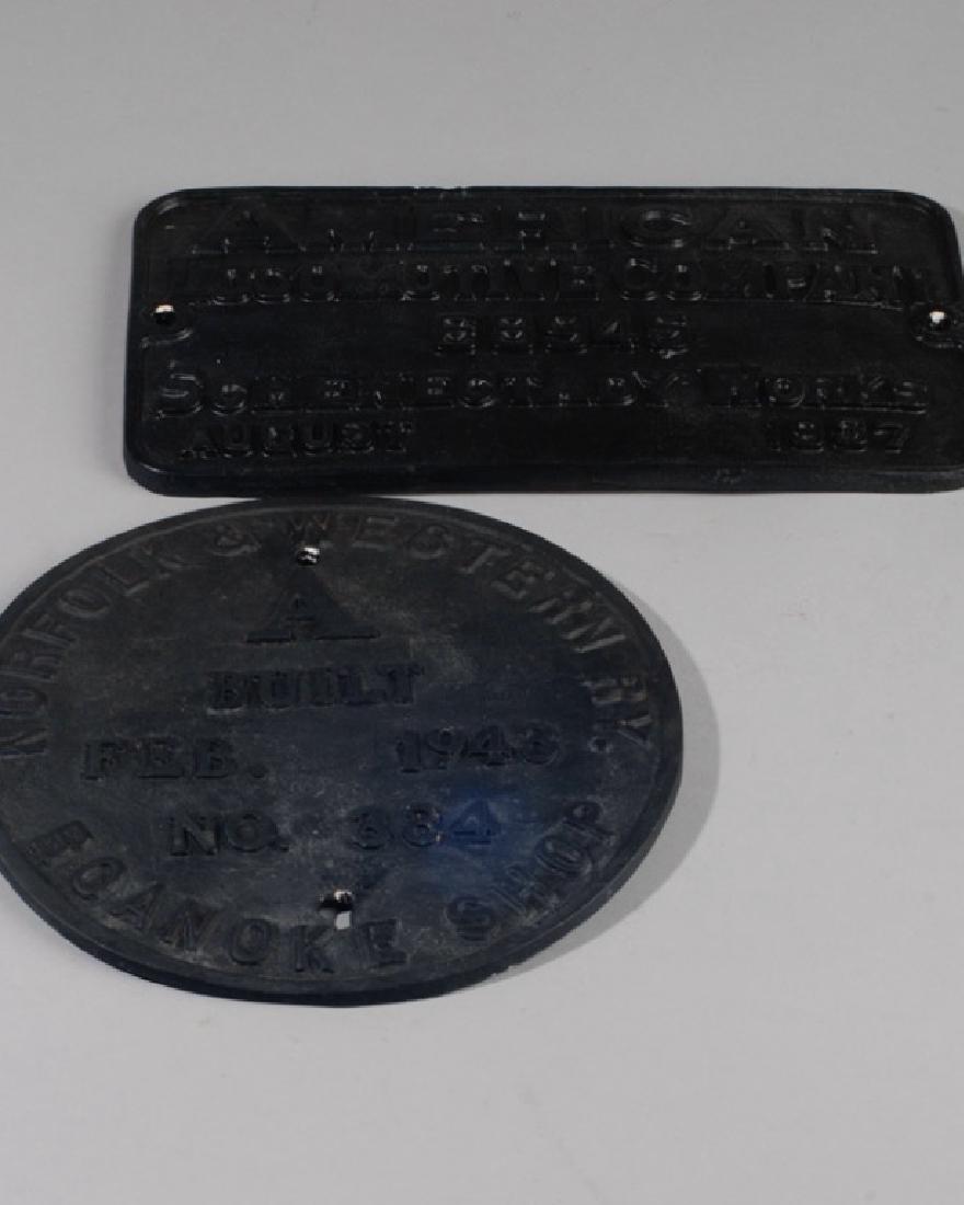 Two Reproduction Composition Railroad Signs: One is "Norfolk & Western Roanoke Shop" the other is "American Locomotive Company". Provenance: The collection of Ken Staples of Charlottesville, VA. Largest Dia: approx. 10 1/2".