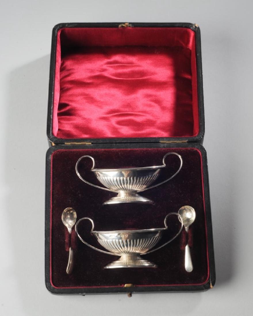 Pair English Sterling Master Salts: Birmingham, made by John Millward Banks circa 1890s, together with two silverplate salt spoons, in original presentation box. Weight (without spoons) approx. 2.41 ozt. H: approx. 2". W: approx. 4 1/4"