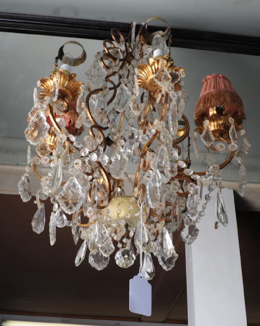 Vintage or Antique 6 Light Crystal Chandelier: Gilt bronze cage with scrolling arms, crowded with a multitude of crystal chains and various sizes and shapes of crystal drops, three original pink pleated silk and ostrich feather shades present. Pos