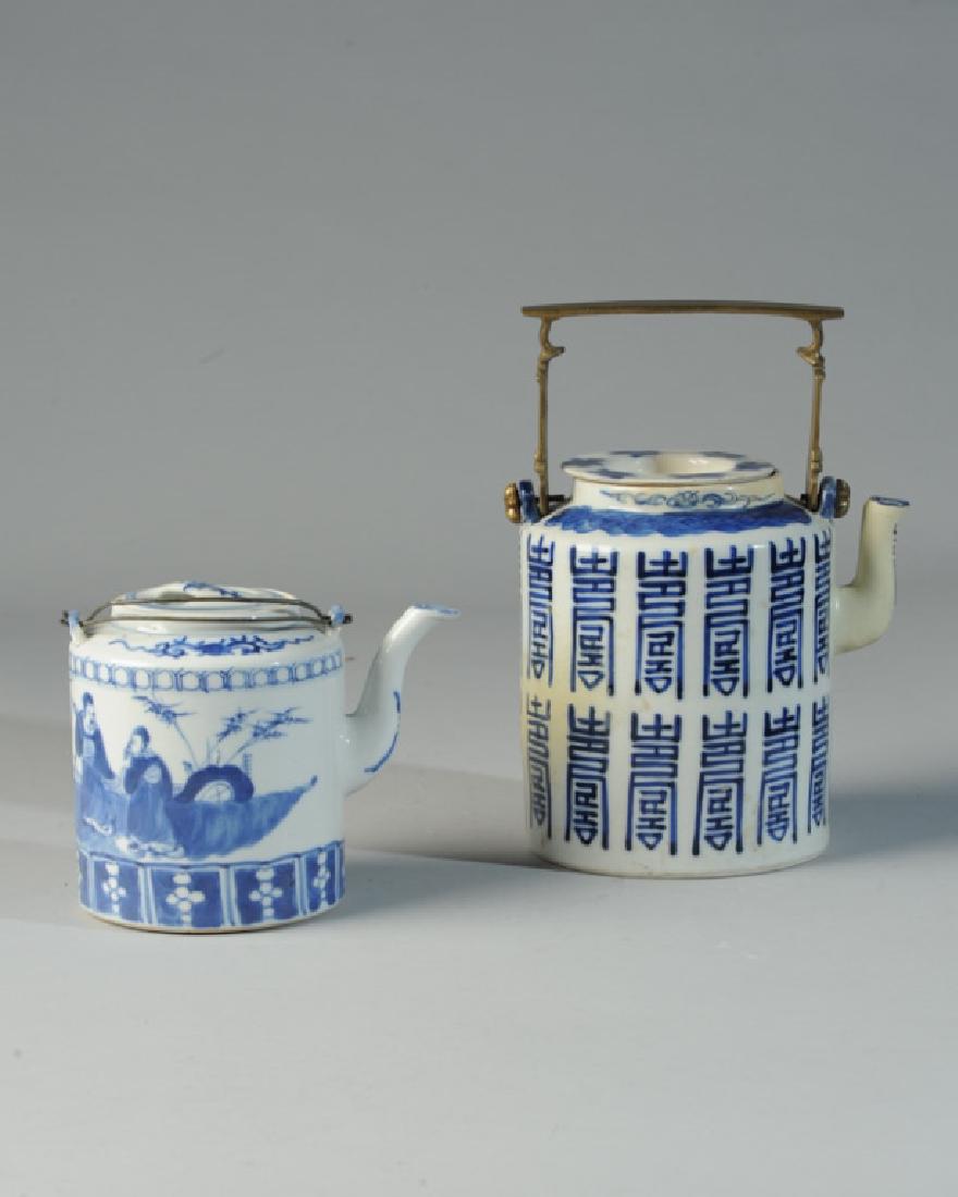 2 Antique Chinese Blue & White Longevity Teapots: Larger has square brass handle, covered with repeating character in archaic script, possibly a variation on the Shou, or longevity character. This teapot has extensive old repainting of spout and one 