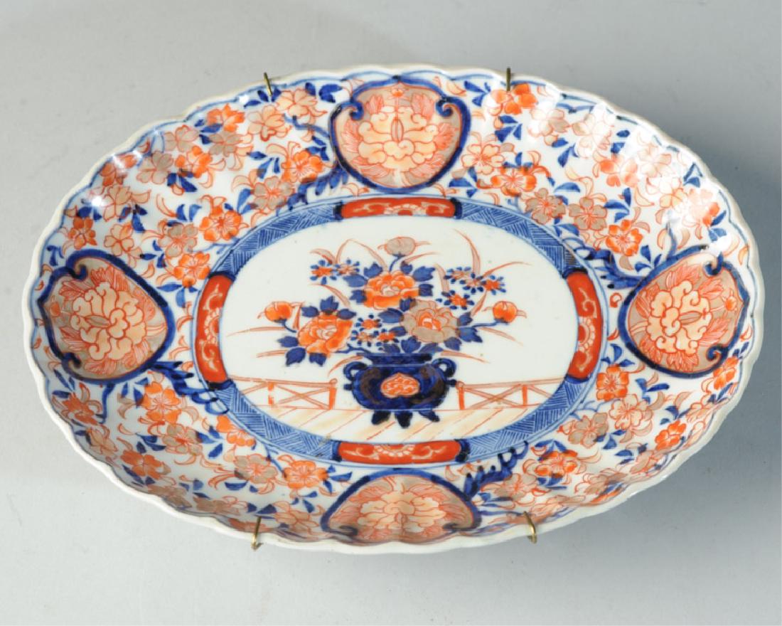 Antique Japanese Imari Platter: With scalloped rim, floral decoration in underglaze blue with red, peach, and gold enamels. Lotus scrolls to underside. Probably 19th century / Meiji period Excellent condition. Approx. 9 3/4" x 7 1/2