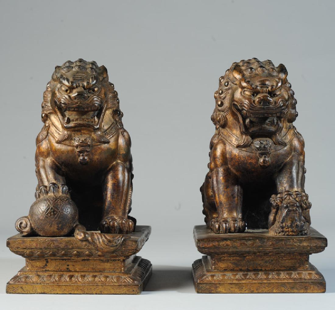 Pair Antique Chinese Gilt Bronze Foo Lions Dogs: Each atop a low platform with incised decoration, one with its paw resting on a brocade ball, the other with its paw holding down a foo lion cub. Excellent detail and patina. Probably 19th C. Each app