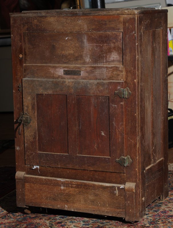 Vintage Oak Ice Box: Probably circa 1920s, with brass plate to front engraved "Mace Empire", missing one foot, in as-found condition. H: approx. 44 1/2". W: approx. 28 3/4". D: approx. 19".