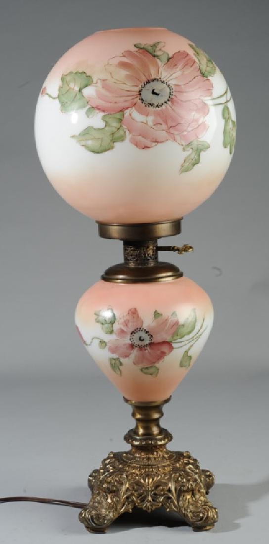 Gone With The Wind Table Lamp: With hand painted milk glass base and globe, ornate brass foot. Very small, shallow chip to top rim of globe. Approx. 24" total height.