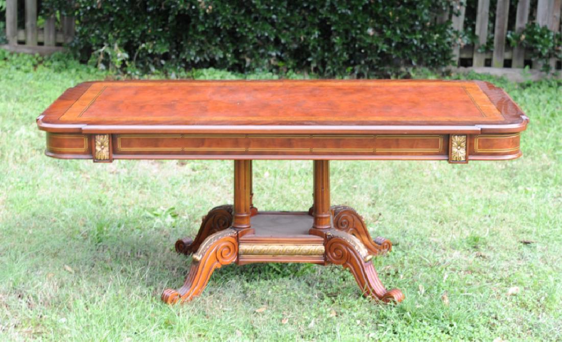 Marquetry Inlaid & Gilt Pedestal Dining Table: Rectangular Regency style dining table with shaped rounded corners, with inlaid crotch mahogany, satinwood and bird's eye maple top and skirt, and with wide platform pedestal with four large scrolling